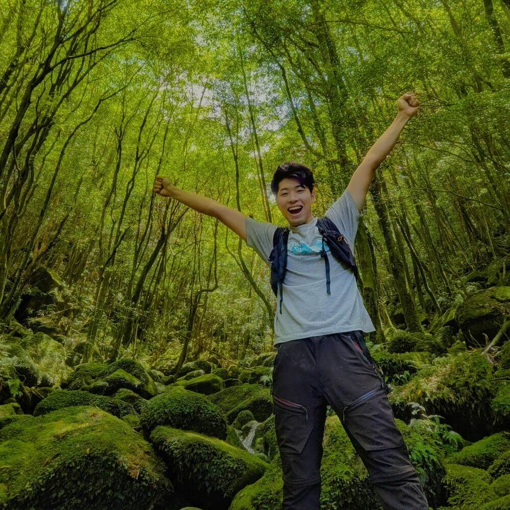 屋久島の苔むす森で深呼吸をする自然ガイドのアンディー(安藤優太)